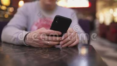 一位年轻的商人坐在咖啡馆的桌子旁，用<strong>iphone</strong>和<strong>短信</strong>打字——成功人士，每天